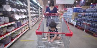 亚洲母亲和儿子在超市购物-新常态概念