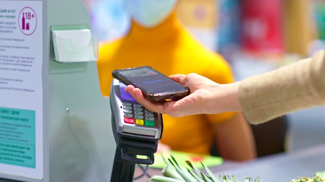 特写，用智能手机付款，nfc。手机被带到支付终端，在超市进行非接触式支付。4 k, ProRes