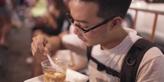 男子吃泰式甜点，软豆腐在热姜糖浆在当地街头小吃