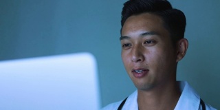 年轻的亚洲医生通过网络与病人交谈