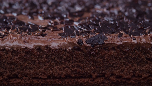 在巧克力蛋糕上撒上巧克力屑。极端特写镜头