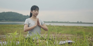 运动亚洲女性坐在冥想姿势姿势医学瑜伽调呼吸平衡在美丽的山景在日出。
