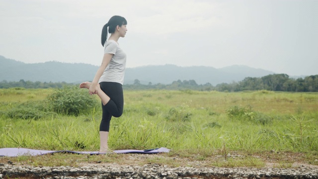 年轻的亚洲白种妇女进行精神瑜伽冥想姿势瑜伽平衡在美丽的山景在早晨日出。
