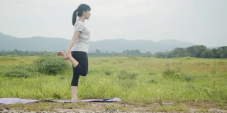 年轻的亚洲白种妇女进行精神瑜伽冥想姿势瑜伽平衡在美丽的山景在早晨日出。