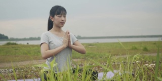 美丽的亚洲女性坐在冥想姿势姿势医学瑜伽调息平衡在美丽的山景在日出。