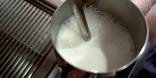 用蒸汽棒在浓缩咖啡机上蒸牛奶