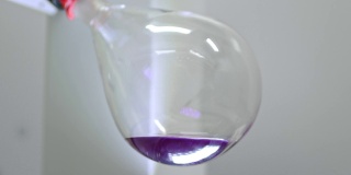 玻璃灯泡在实验室蒸发器中旋转。科学医学实验室。一种用于液体蒸发的装置。烧瓶在旋转。研究和搜索。试管中的紫色液体。