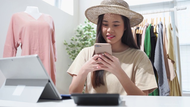 一名亚洲女性在网上销售复古服装，她在社交媒体上直播。