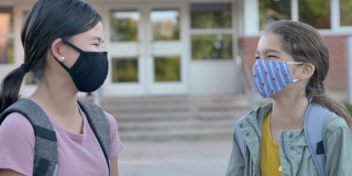 两个小学同学戴着面具站在外面