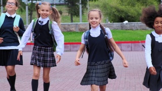 身着制服的可爱女孩们迎着鲜花在校园里奔跑视频素材模板下载