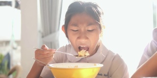 亚洲学生在上学前一起在家吃早餐。