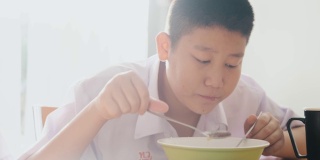 亚洲学生在上学前一起在家吃早餐。