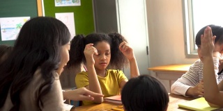 亚洲学校的老师在课堂上帮助学生