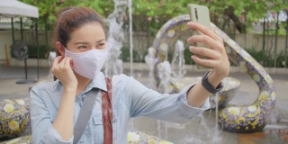 亚洲成年女子在泰国当地旅游时自拍。有魅力的女性在当地旅游时，用智能手机给社交媒体上的朋友打电话。独行侠的概念。