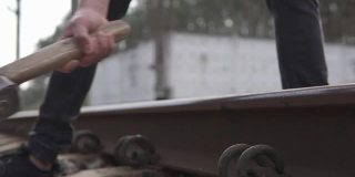 铁路工人用大锤锤击尖顶来修理铁路。