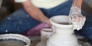 亚洲华人活跃的高级男子波特在他的工作室与纺织陶瓷轮工作