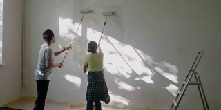 日本夫妇用油漆滚筒在家里刷墙