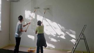 日本夫妇用油漆滚筒在家里刷墙视频素材模板下载