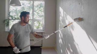 日本一名男子用油漆滚筒刷墙视频素材模板下载