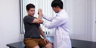 亚洲理疗师检查接受过矫形康复治疗的患者的肘部。