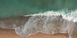 金沙海浪和绿松石海水与白色泡沫从小海浪风景鸟瞰图。暑假的概念。明亮的抽象背景适合任何设计。无人机的幻灯片