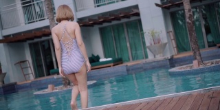 亚洲女人放松在度假的游泳池