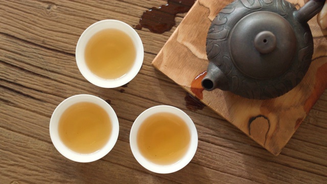 将热茶倒入茶杯中