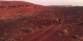 三个十几岁的年轻人和弟弟妹妹纳瓦霍印第安人骑着他们的马在沙漠附近的纪念碑谷部落公园在夏天的黄昏