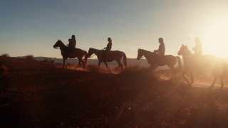 在夏季黄昏的纪念碑谷部落公园附近的沙漠里，纳瓦霍印第安人骑着他们的马视频素材模板下载