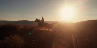 在亚利桑那州北部纪念碑谷部落公园附近的纳瓦霍保留区，年轻的美国土著纳瓦霍男孩骑着他的无鞍马