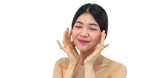 美丽和性感的亚洲女人的肖像在白色的背景。美丽的女人触摸她的脸，对着镜头微笑