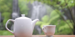 静物近距离茶具在花园与瀑布的背景