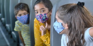 小学生在公共汽车上戴着口罩
