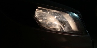 汽车在夜间行驶时发出的耀眼的车头灯。