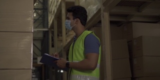 年轻的印度工厂仓库工人戴着防护口罩在物流行业工作。30人检查Covid - 19大流行期间的物品库存订单
