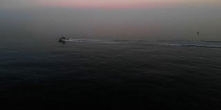 一艘渔船在英吉利海峡色彩斑斓的水域上快速行驶