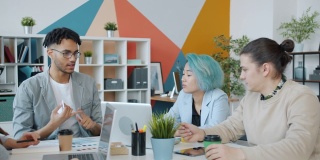 现代青年设计师团队在共享办公室的餐桌上交谈