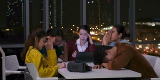 亚洲女性领导者和ux, ui开发人员和程序员团队在晚上在办公室认真开会，工作到很晚