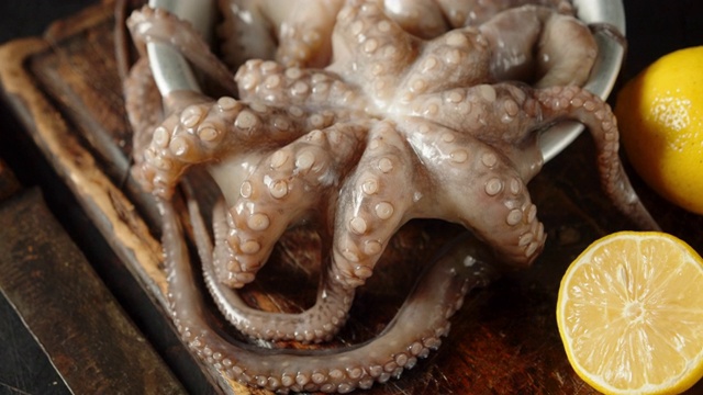 生章鱼在切菜板上的碗中旋转。