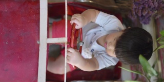 一个亚洲男孩在咖啡馆里玩一辆红色玩具车