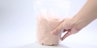 粉红色的盐在透明的塑料袋孤立在白色的背景。包装模板模型收集。