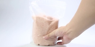 粉红色的盐在透明的塑料袋孤立在白色的背景。包装模板模型收集。