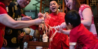 亚洲华人家庭春节团圆饭吃传统菜肴生鱼刘生