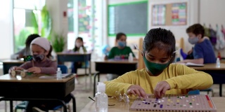 2019冠状病毒病期间，戴口罩的学生在教室里
