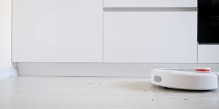 一个机器人吸尘器从地板上捡垃圾的特写，侧视图