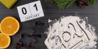 为圣诞节和新年准备节日大餐。日历，日期为1月1日。公牛作为2021年新年的象征。平面布局。饼干模具和面粉。橘子和八角。