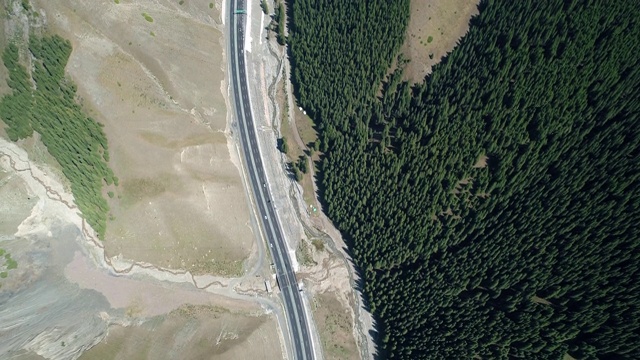 森林与山脉之间的新疆高速公路俯视图