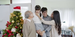 快乐的亚洲三代同堂在检疫圣诞享受拍照拍摄合影合影一起站在家里公寓与圣诞树享受闲暇时光。