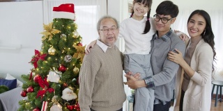 幸福的亚洲三代家庭在检疫圣诞快乐享受拍照拍摄合影合影站在家里公寓享受闲暇时间与圣诞树。