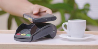 用手机付款。2019冠状病毒病大流行期间，小咖啡店采用NFC技术的非接触式支付。社交距离可以让曲线变平。
